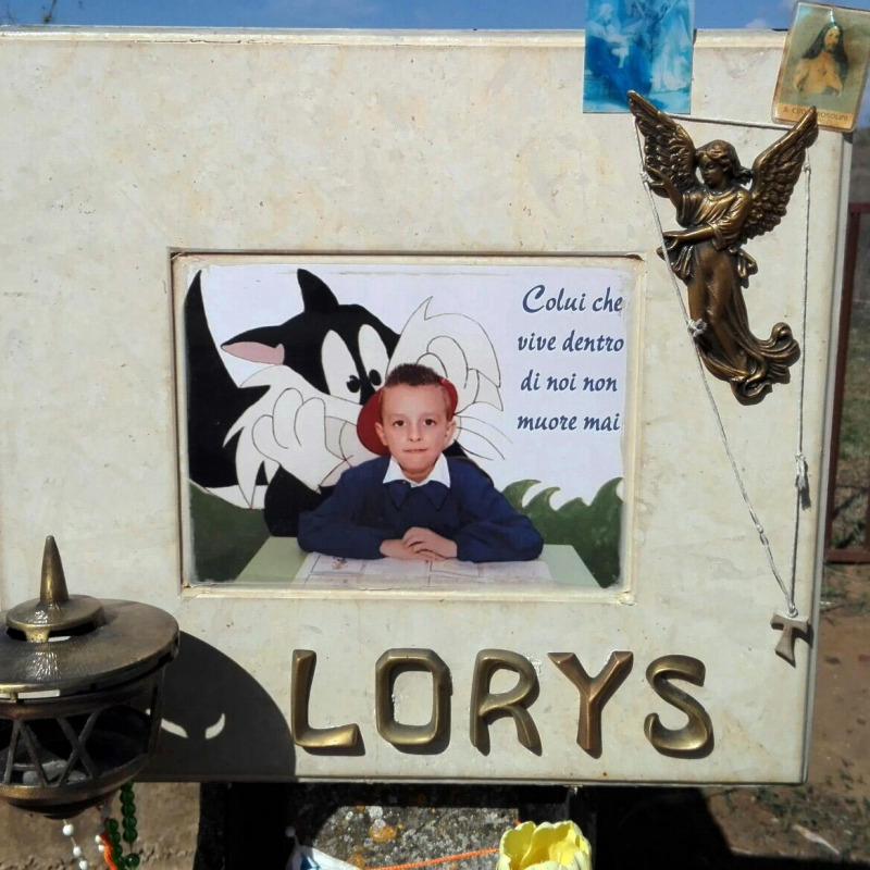 La foto di Loris con la scritta "colui che vive dentro di noi non muore mai" - Fonte Ansa