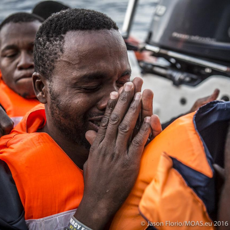 Un migrante appena sbarcato, in lacrime, ringrazia di avere superato la traversata in mare