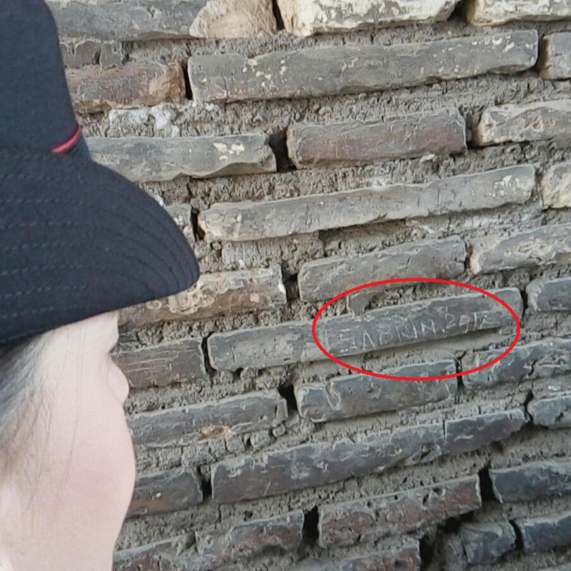 L'incisione della turista su un pilastro del Colosseo (Ansa)