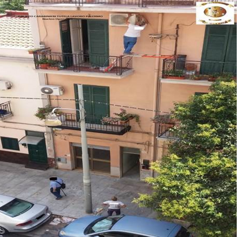 La foto dell'operaio in bilico tra due balconi in via Ausonia a Palermo