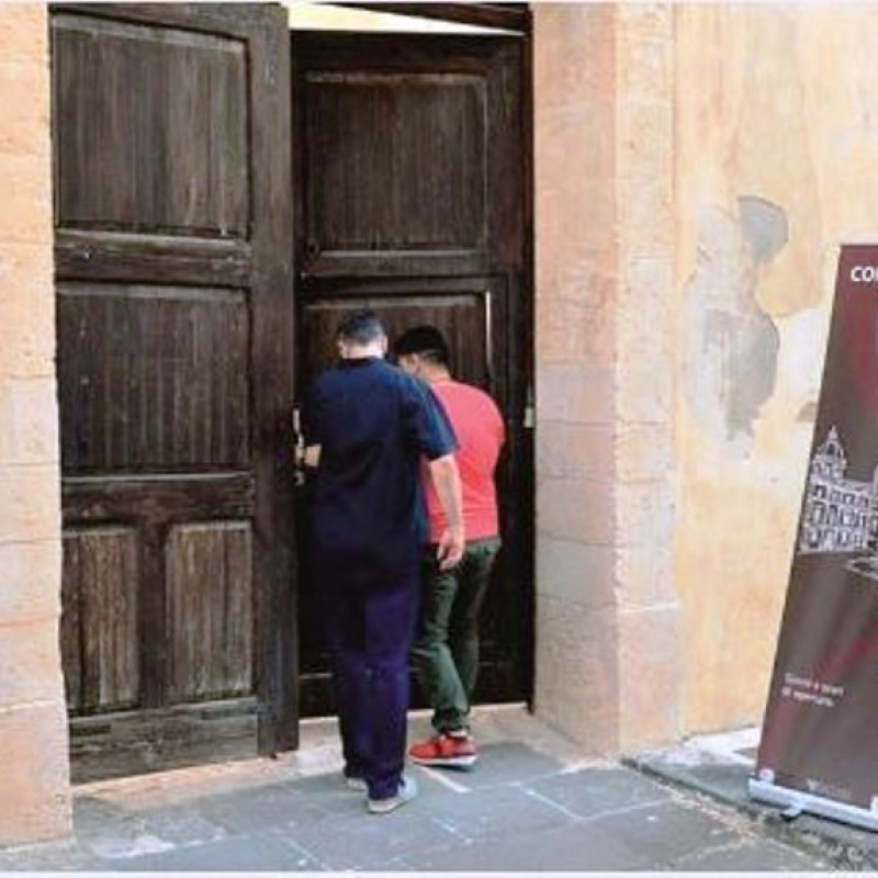 Due detenuti che varcano il portone d'ingresso dell'ex convento di Sant'Antonio da Padova (foto Rosana)