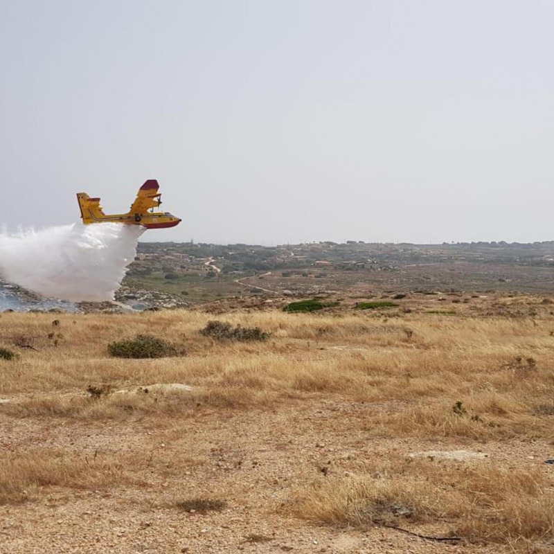 Un Canadair in azione per spegnere il vasto incendio divampato nel Centro di raccolta dei rifiuti di Lampedusa nel 2019