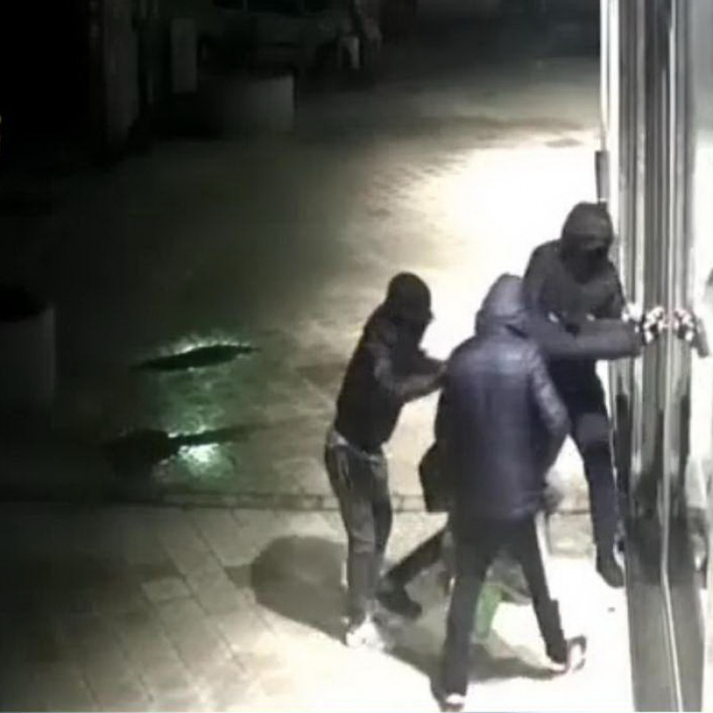 Un'immagine riprende la banda mentre prova a forzare la vetrina di un negozio