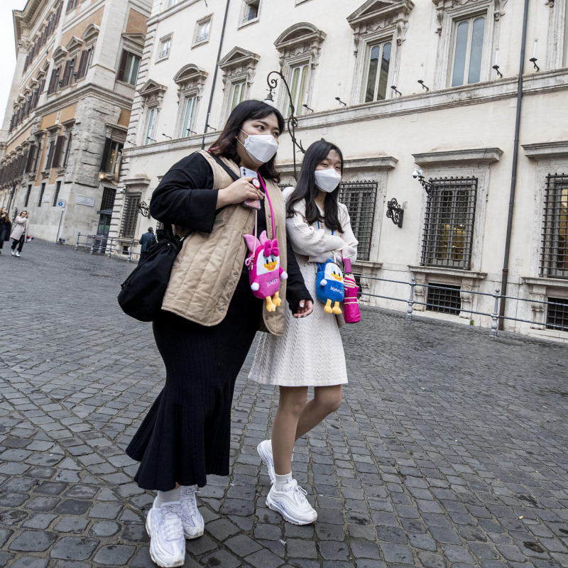 Turisti cinesi con la mascherina a piazza Colonna a Roma