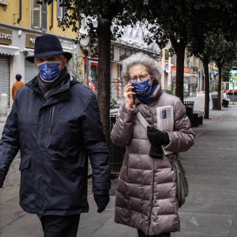 Persone indossano mascherine protettive all'esterno dell'ospedale Papa Giovanni XXIII durante l'emergenza Coronavirus a Bergamo
