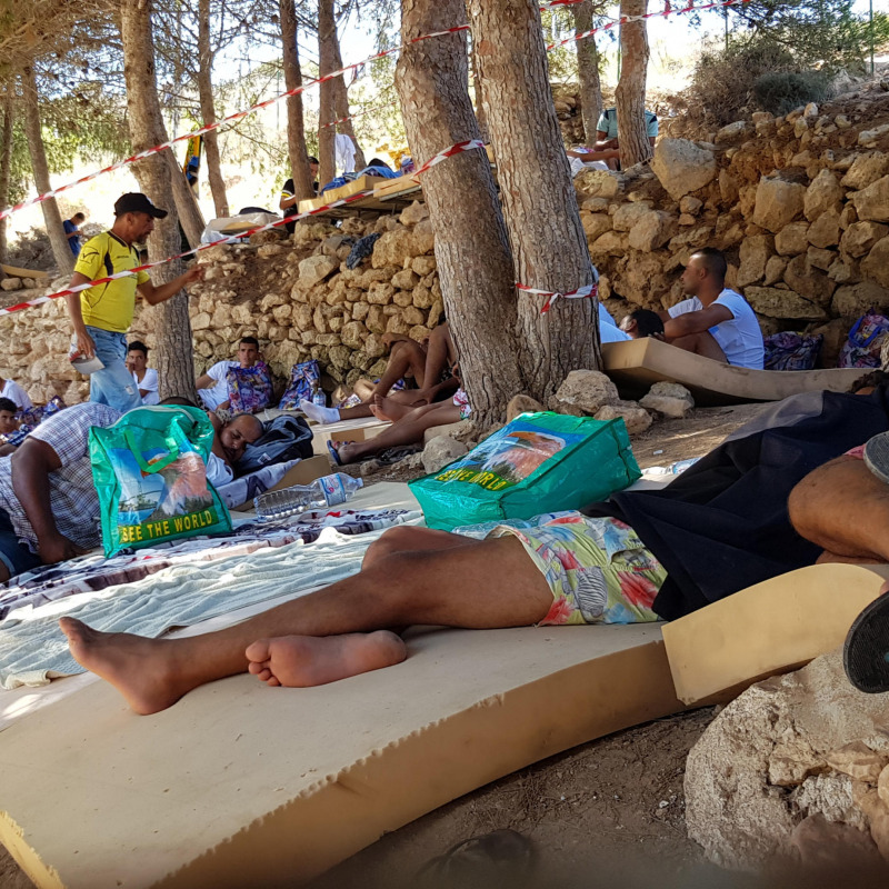 Migranti dormono a terra all'interno dell'hotspot