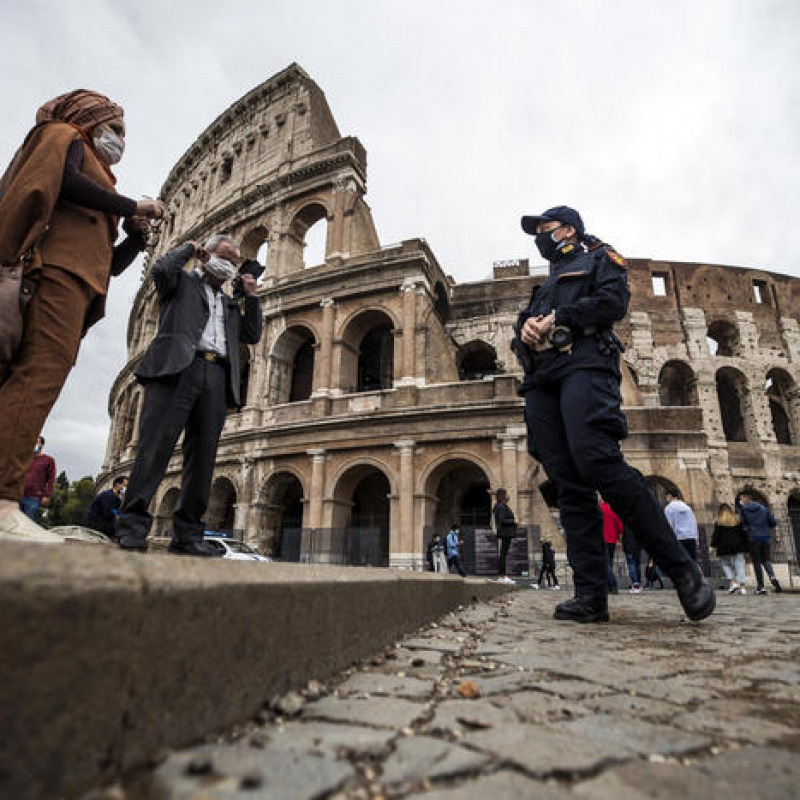 Un poliziotto con alcuni turisti davanti al Colosseo