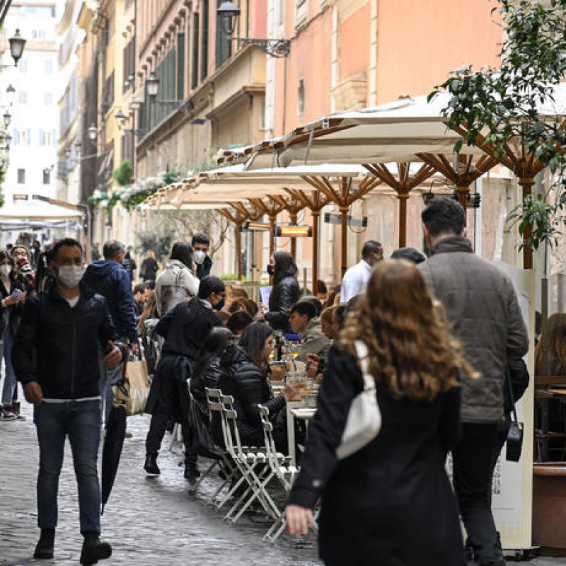Persone con le mascherine in una strada di Roma