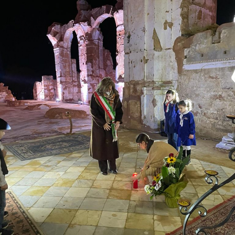 Il sindaco Margherita La Rocca Ruvolo depone un lumino ai piedi della Croce, al centro di ciò che rimane dell'abside della chiesa madre di Montevago