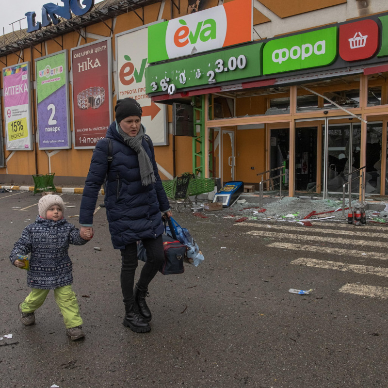 Una donna cammina davanti alle macerie di un supermercato a Kiev
