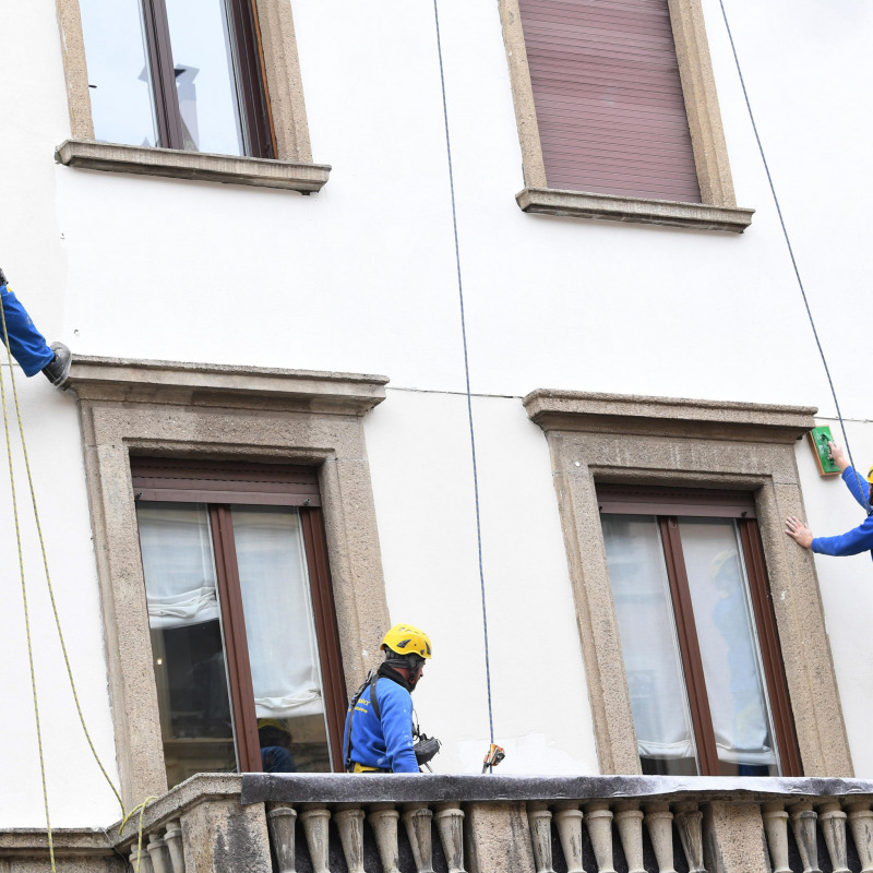 Operai acrobati al lavoro su un facciata di un palazzo