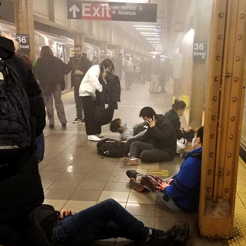 Gente in terra sulla banchina della metropolitana a Brooklyn dopo una sparatoria