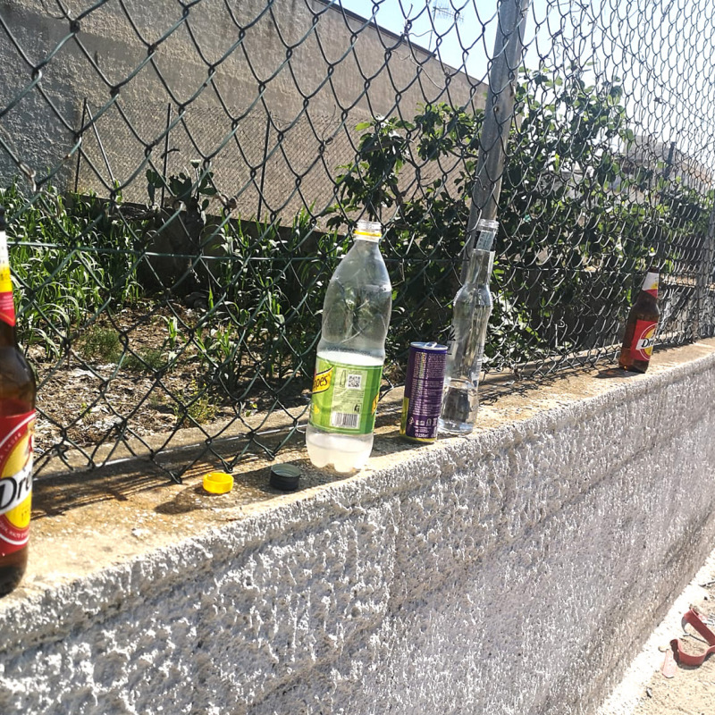 Bottiglie lasciate su un muretto vicino alla spiaggia di Tre Fontane