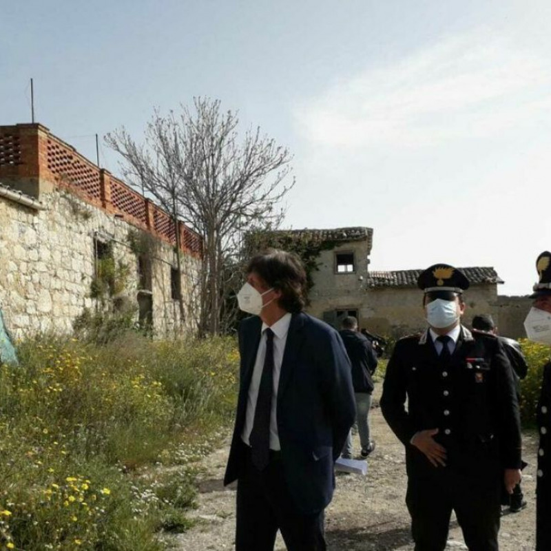 In una foto dell'anno scorso il procuratore Patronaggio e i carabinieri consegnano alla coop Livatino i terreni di contrada Gibbesi
