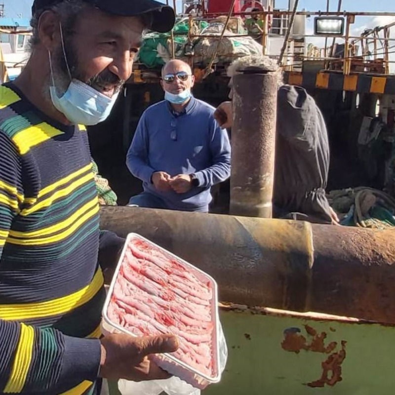 Un pescatore di Mazara con un «cartone» di gambero rosso (foto Mezzapelle)