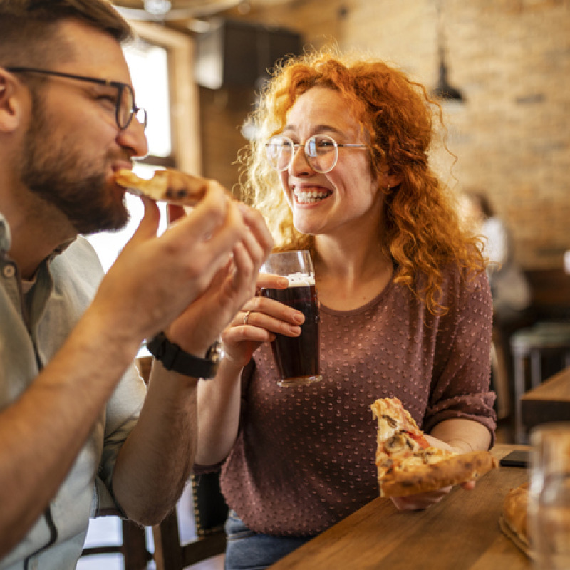 Un uomo e una donna sorridenti mangiano insieme foto iStock.