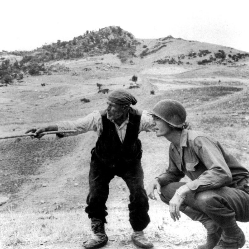 Una famosa foto di Robert Capa di un contadino siciliano che indica ad un soldato statunitense la via scelta dai tedeschi per la fuga