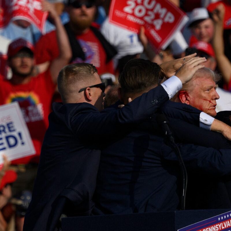 BUTLER, PENNSYLVANIA - JULY 13: Republican presidential candidate, former U.S. President Donald Trump is whisked away by Secret Service after shots rang out at a campaign rally at Butler Farm Show Inc. on July 13, 2024 in Butler, Pennsylvania. Trump slumped and injuries were visible to the side of his head. Butler County district attorney Richard Goldinger said the shooter and one audience member are dead and another was injured. Jeff Swensen/Getty Images/AFP (Photo by JEFF SWENSEN / GETTY IMAGES NORTH AMERICA / Getty Images via AFP)