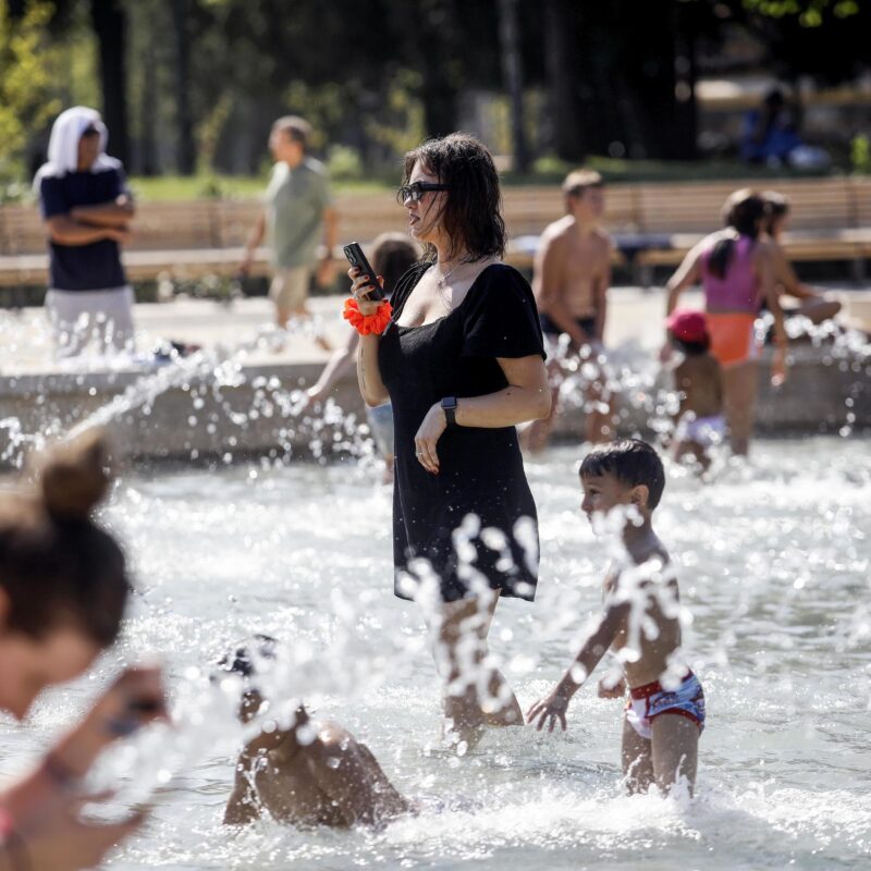 Caldo in città - milanesi e turisti si rinfrescano a causa dellalta temperatura nella fontana di piazza Castello a Milano, 9 agosto 2024. ANSA/MOURAD BALTI TOUATI